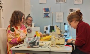 Kuvassa on Kalevan hallilla järjestetyn vaatteen korjaustyöpajan osallistujia.